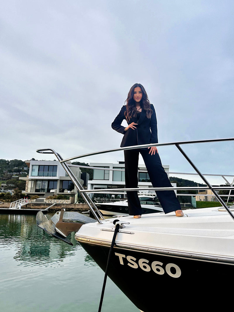 Person standing on a boat with a modern house in the background