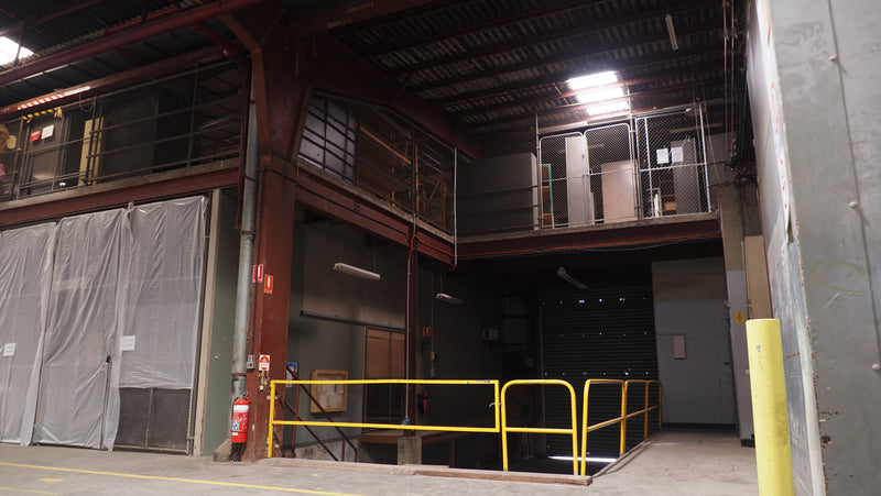 Industrial warehouse loading bay with open door and yellow safety railing