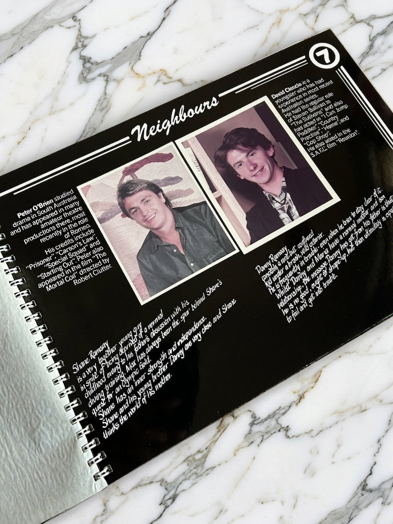Spiral-bound book with images and text on a marble surface