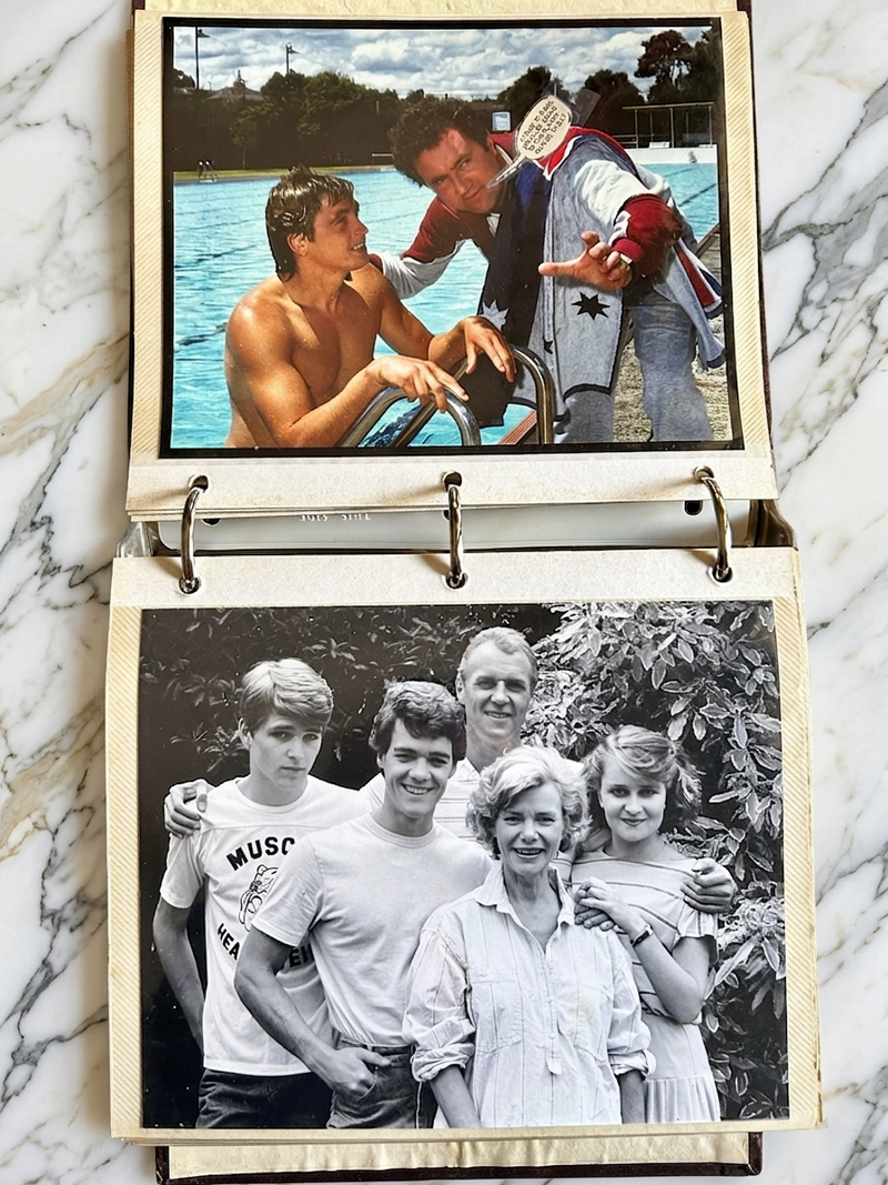 Two photo albums open to family photos on a marble surface.