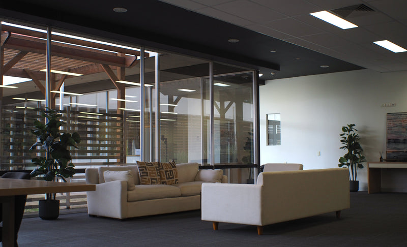 Modern office lounge with beige sofas, a coffee table, and decorative elements.