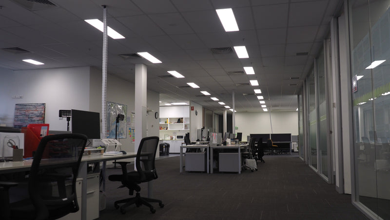 Empty office space with desks, chairs, and computers.