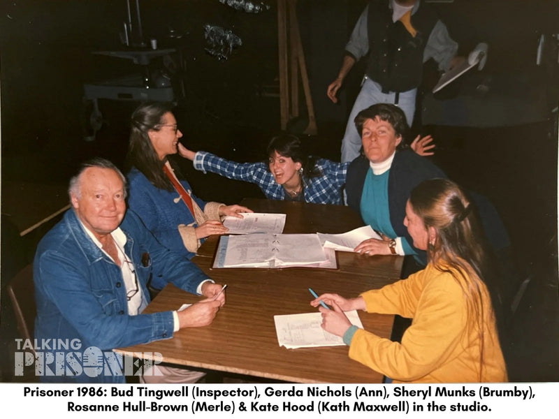 Group of people sitting around a table in a studio setting, with text indicating their roles in 'Prisoner 1986'.