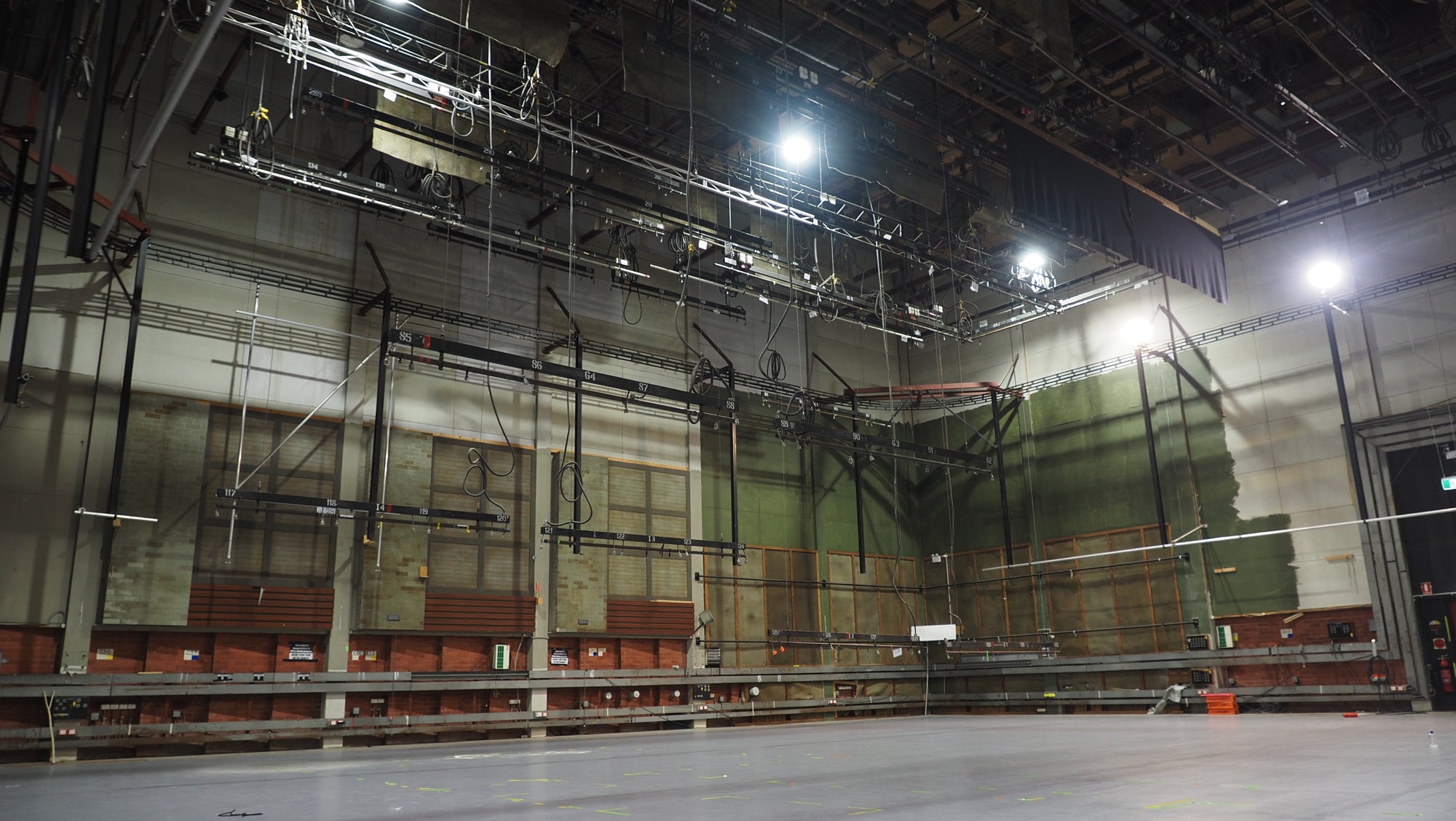 Large production studio with high ceilings and grey flooring