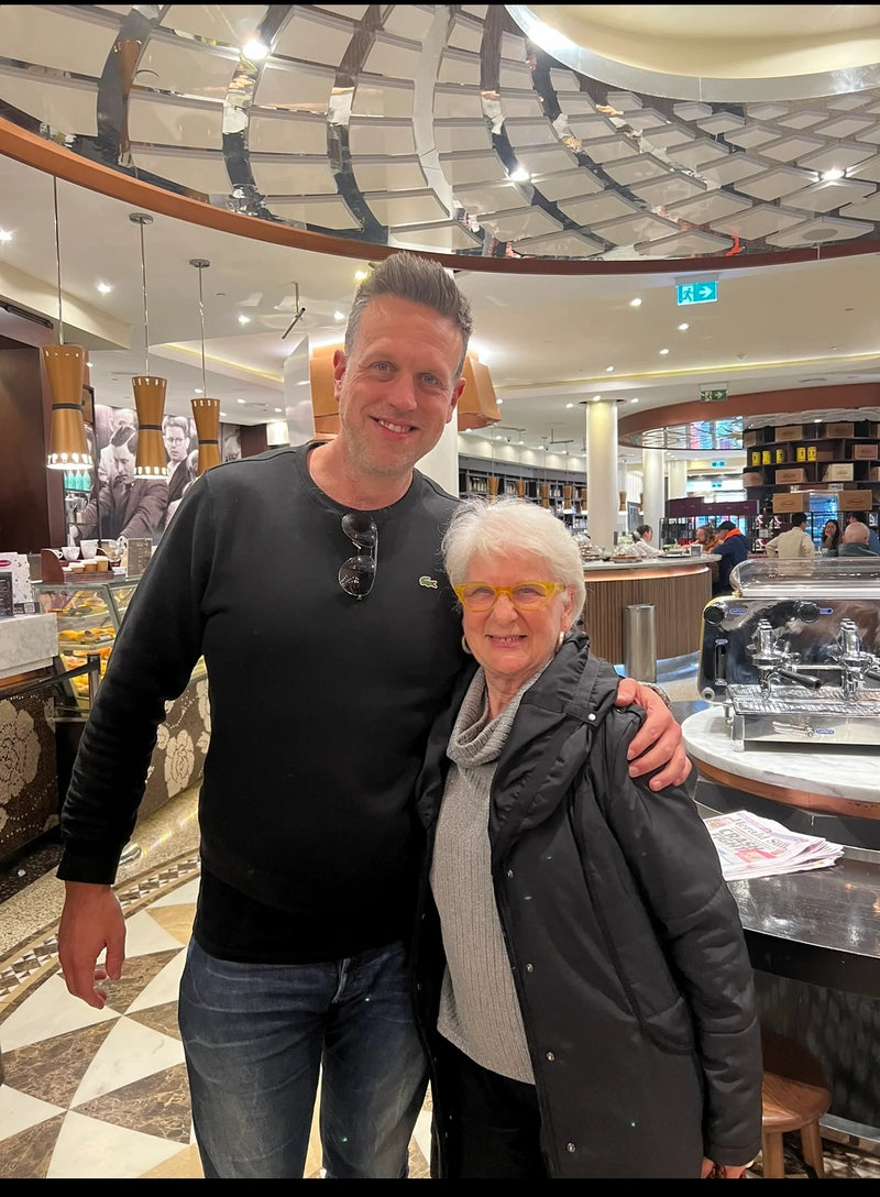 Two people standing together in a cafe with a modern architectural design.