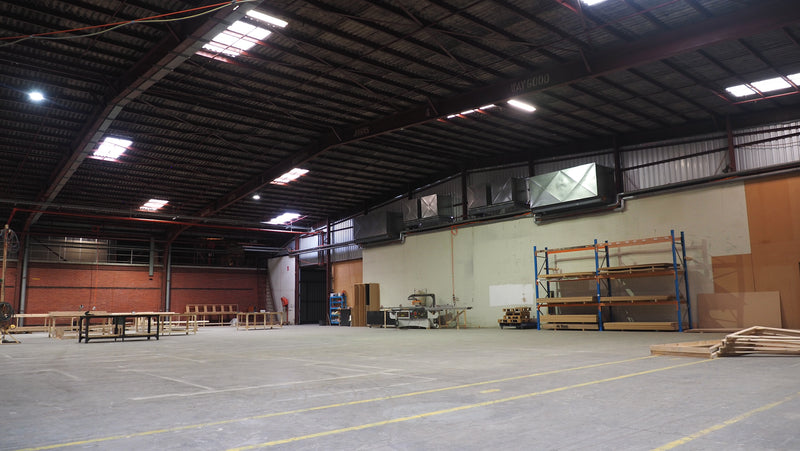Large warehouse interior with various equipment and materials.